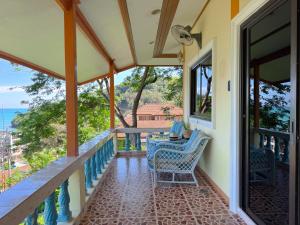 a porch with a table and chairs and the ocean at Sea Dreamer Ao Yon Beach House in Ban Ao Makham