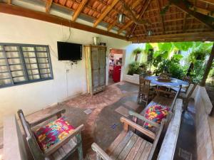 Rancho Lindas Aguas Carmo do Rio Claro في كارمو دو ريو كلارو: فناء مع طاولة وكراسي وتلفزيون
