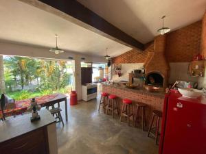 Rancho Lindas Aguas Carmo do Rio Claro في كارمو دو ريو كلارو: مطبخ مع طاولة وثلاجة حمراء