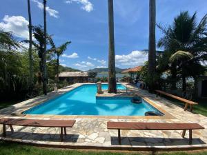 Rancho Lindas Aguas Carmo do Rio Claro في كارمو دو ريو كلارو: مسبح على كرسيين في منتجع
