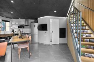 a kitchen and dining room with a table and a staircase at Fun Art Blokhus in Blokhus