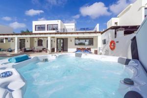 a swimming pool in front of a house at Villa Bella Valen in Playa Blanca