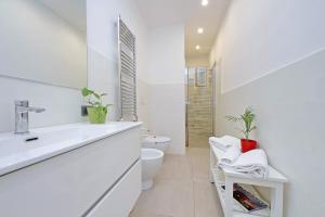 a white bathroom with a sink and a toilet at YCH-Luminoso appartamento nel cuore di Testaccio in Rome +16 photos