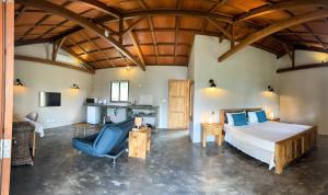 a bedroom with a large bed and a kitchen at Lakaz Kannell - Coconut Lodge secluded outside shower, infinity pool in Cap Malheureux +47 photos