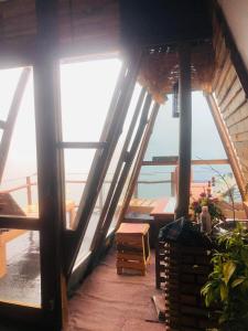 a room with a balcony with a view of the ocean at Prince Place Eco Cabana and Camping Site in Passara