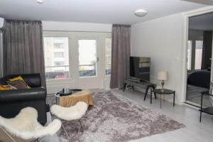 ein Wohnzimmer mit Sofa und Fernseher in der Unterkunft Kotimaailma Penthouse 2 in Lahti