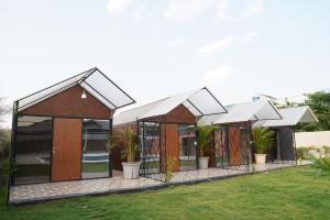a group of three buildings with plants in them at Great Escape Club Indore in Indore