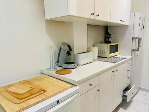 a kitchen with white cabinets and a counter top at Maisonnette au calme proche T2 in La Garenne-Colombes