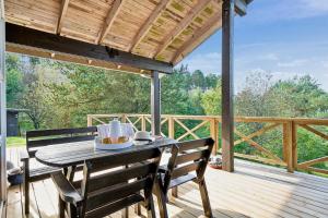 a wooden deck with a table and chairs on it at Cozy Holiday Home On Helgenæs in Knebel
