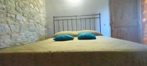 a bed with two blue pillows on top of it at Guesthouse Nicol in Collelungo