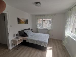 une chambre blanche avec un lit et une fenêtre dans l'établissement Ferienwohnung bei Bojko, à Oberkirch