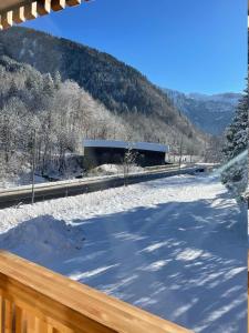 a snow covered yard with a building in the background at Apartment Kanisfluh in Mellau +21 photos
