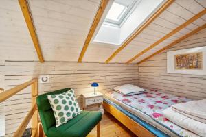 a bedroom with a bed and a chair in a attic at Cozy Holiday Home On Helgenæs in Knebel