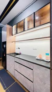 a kitchen with stainless steel cabinets and a counter at Spacious Apartment near IIUM Medical Centre, ECR & Teluk Cempedak with Smart TV & Pool in Kuantan