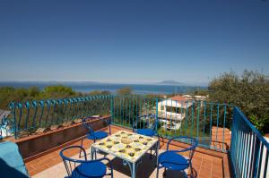 un patio con tavolo e sedie sul balcone. di Villa Eva ad Anacapri