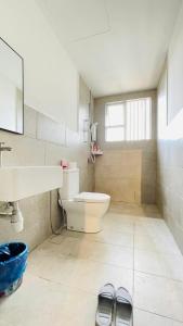a bathroom with a toilet and a sink and two slippers at Spacious Apartment near IIUM Medical Centre, ECR & Teluk Cempedak with Smart TV & Pool in Kuantan