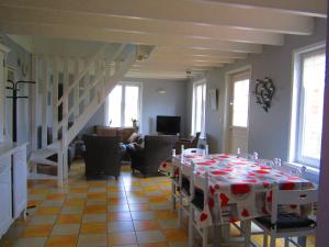 sala de estar con mesa y mantel rojo y blanco en Gîte Marais Atypique en Clairmarais