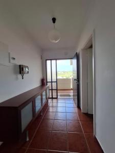 Un pasillo con suelo de baldosas y una puerta con vistas en Populo Beach Apartment, en São Roque