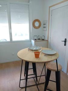 einen Holztisch mit zwei Hockern in einem Zimmer in der Unterkunft Coquet T2 proche de la Mairie in Sète + 3 Fotos