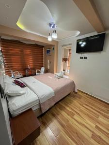a bedroom with a large bed and a flat screen tv at Hotel Los Inkas in Huaraz