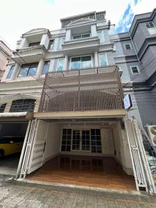a large house with a wooden porch with a balcony at Comfy Crib Hostel 2 in Bangkok