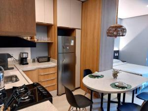 a kitchen with a table with chairs and a refrigerator at Flat - Casas de Alter in Alter do Chao