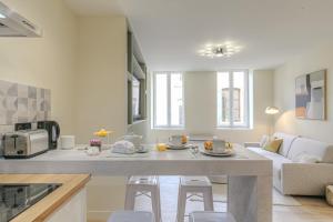 una cucina e un soggiorno con un tavolo e un divano di La suite Guillaume, T2 cosy contemporain a Vienne