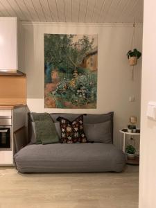a couch in a living room with a painting on the wall at Bellmangården in Matfors +1 photo
