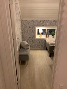 a bedroom with a bed and a chair and a mirror at Bellmangården in Matfors