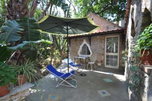 a patio with two chairs and an umbrella at Villa Eva in Anacapri
