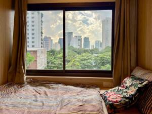 a bedroom with a window and a bed in front of it at Comfy Crib Hostel 2 in Bangkok