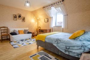 a bedroom with a bed and a couch and a window at La garenne in Éguilly-sous-Bois