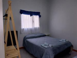 un dormitorio con una cama y una ventana en La casita, en El Calafate