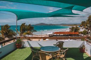 un patio con tavolo, sedie e spiaggia di Hotel Albemarle Galapagos Beachfront a Puerto Villamil Altre 37 foto