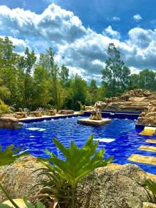 a swimming pool with blue water in a garden at Hotel Casa Cantabria Campestre in Villa de Leyva
