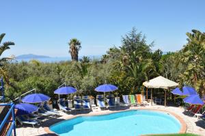 a pool at a resort with chairs and umbrellas at Villa Eva in Anacapri