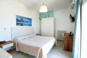 biała sypialnia z łóżkiem i oknem w obiekcie Hotel Approdo di Venere w mieście Vieste