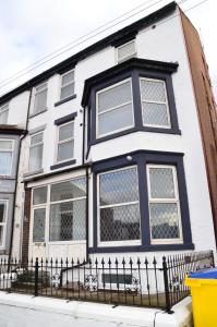 a white and blue house with a black fence at Blok 3 -Jacuzzi Suites, Apartment & Ensuite Rooms in Blackpool