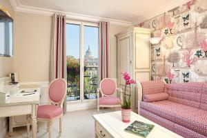 a living room with a couch and pink chairs at Relais Saint Jacques in Paris