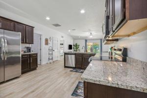 a large kitchen with wooden floors and stainless steel appliances at Herbalist Farm in Jacksonville +17 photos