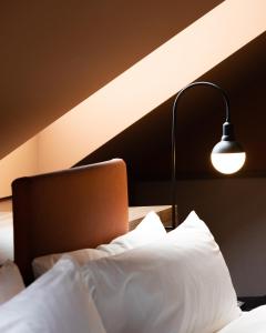sypialnia z łóżkiem z lampką i laptopem w obiekcie Mayburg Salzburg, a Tribute Portfolio Hotel w mieście Salzburg