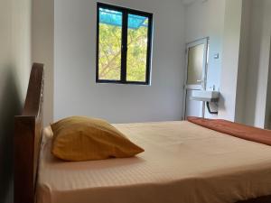 a bedroom with a bed with a window at Marigold Negombo in Negombo
