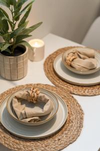 three plates on a table with a plant and candles at Modern apartment with wifi and new furniture - Free parking in Haugesund +8 photos
