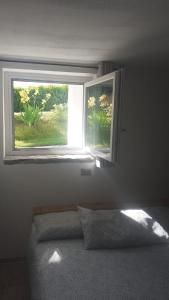 a window in a bedroom with a bed in front of it at Le Glacier in La Salle