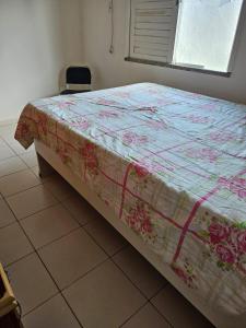 un letto con una trapunta in una camera da letto di Casa de Paraia em Aracaju ad Aracaju