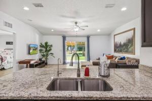 a kitchen with a sink and a living room at Herbalist Farm in Jacksonville