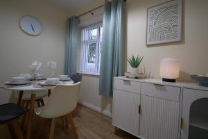 a dining room with a table and a window at Dundrine Cottage in Maghera