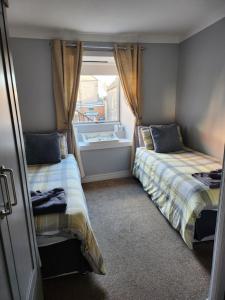 a small room with two beds and a window at Kings Head in Berwick-Upon-Tweed