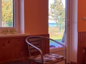 a chair sitting in a room with a window at Pirts cottage in Kaltene