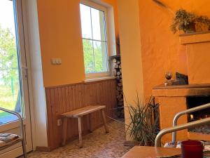 a room with a bench in front of a fireplace at Pirts cottage in Kaltene